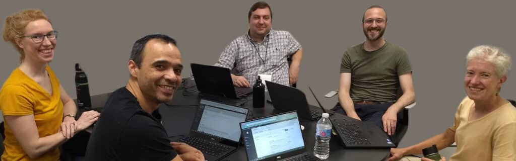 A group of men and women sitting around a table together at the PKP University of Pittsburgh Sprint, 2019.